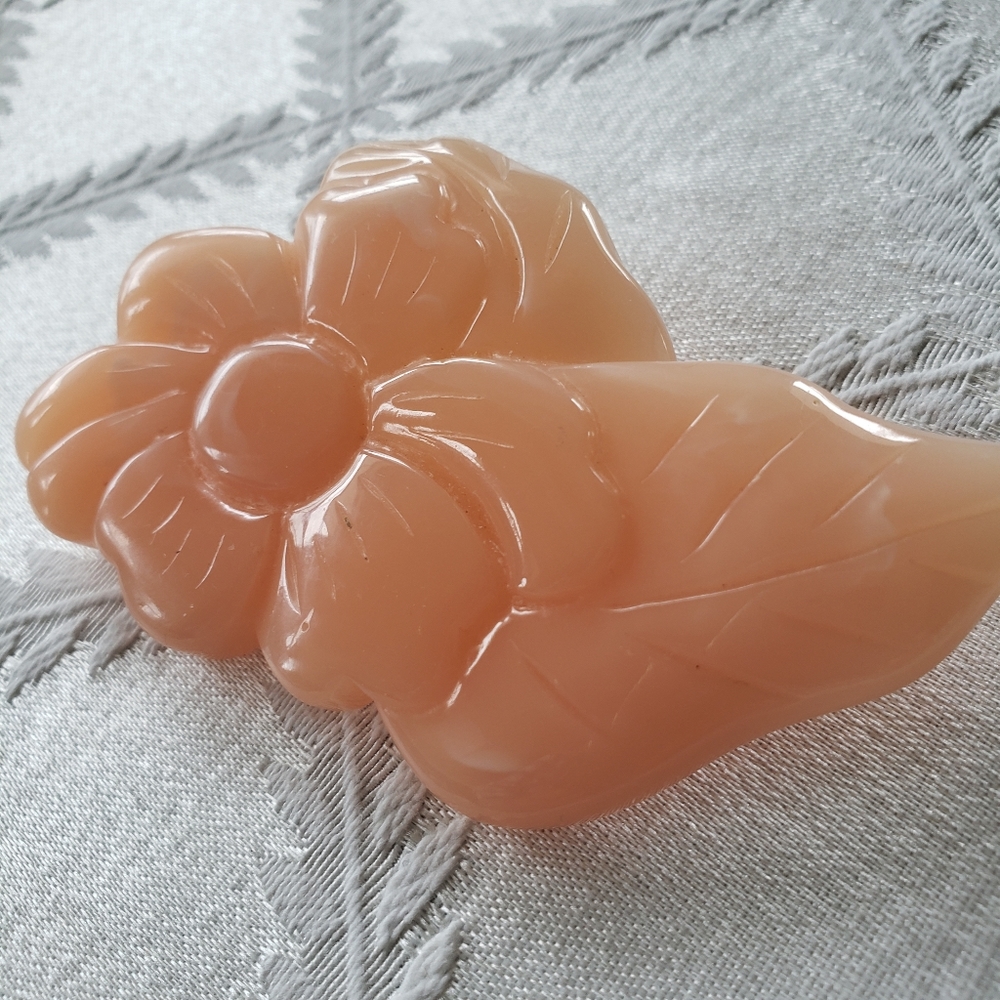 Vintage brooch.  Some form of plastic.  Engraved flower.